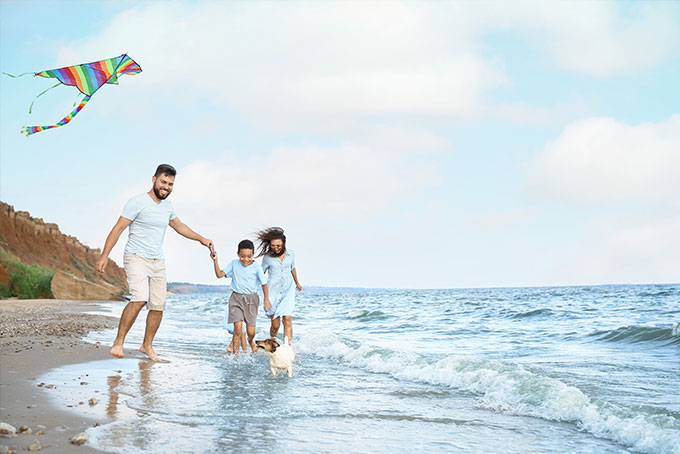 Man running on beach with children