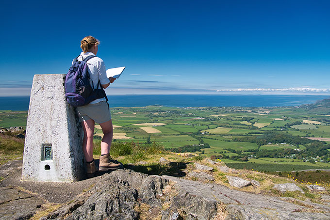 Two people walking in countryside with Osprey bags