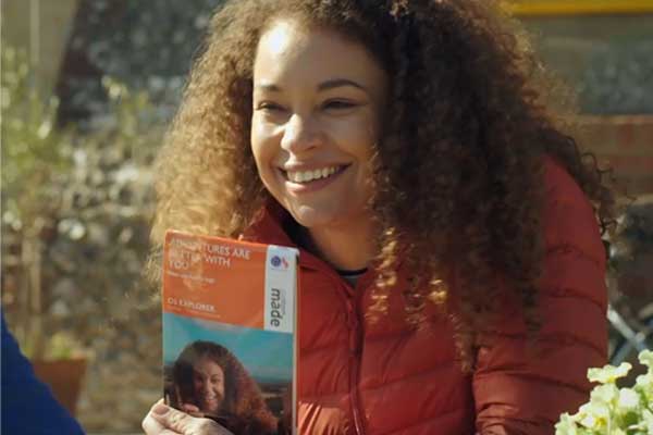 A person holding a customised map with their face on the cover