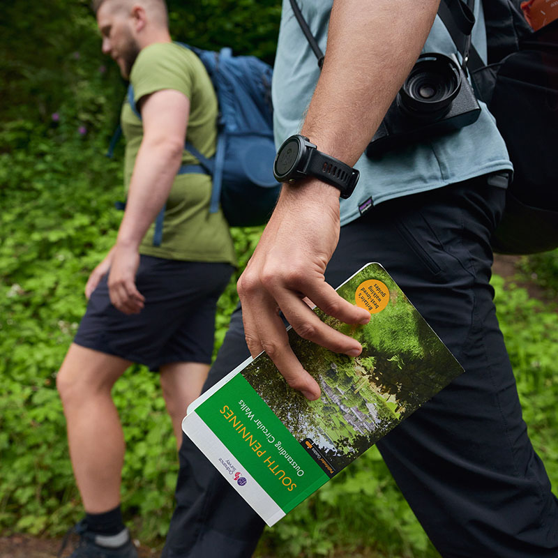 A walker holding a Pathfinder guidebook
